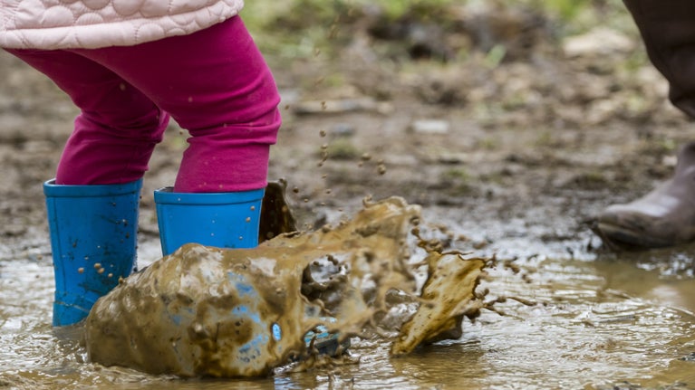 Child jumping in puddles